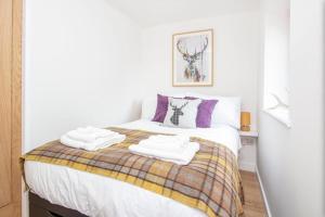 een slaapkamer met een bed met handdoeken erop bij The Nook in Inverness