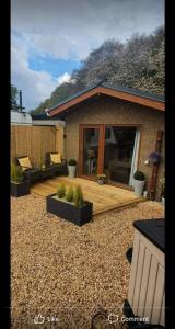 a house with a wooden deck with plants in a yard at The Nook in Inverness