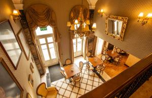 einen Blick über ein Zimmer mit einem Tisch und Stühlen in der Unterkunft Mozart Hotel in Szeged