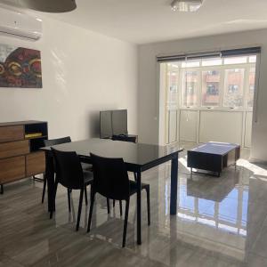 a dining room with a black table and chairs at F7 Room 3, Private Bedroom two single beds shared bathroom in shared Flat in Msida