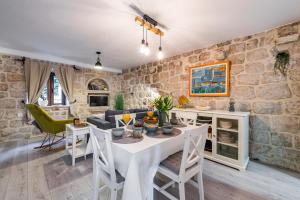 a kitchen and living room with a white table and chairs at Villa Dovecote with Private Sauna, Jacuzzi & Gym in Ston