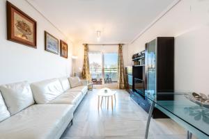 a living room with a white couch and a glass table at Piso encantador junto al mar, relax, tranquilidad in Torre del Mar