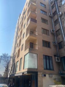 a tall building with a balcony on the side of it at Northern Avenue Apartment in Yerevan