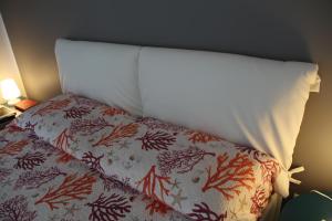 1 cama con cabecero blanco y colcha con algas rojas en Venere - Taormina Minerva Luxury Apartment by Taormina Holidays, en Taormina 6 fotos más