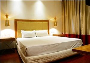 een slaapkamer met een groot wit bed met 2 lampen bij HOTEL AMORA - Rajnandgaon in Rāj Nāndgaon