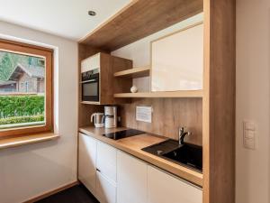 a kitchen with white cabinets and a sink and a window at Apartment in Wald near Zillertal Ski Slopes in Wald im Pinzgau