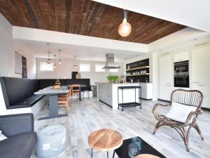 uma sala de estar em plano aberto e uma cozinha com uma mesa e cadeiras em Classy Holiday Home in Sint Annaland Barbecue em Sint-Annaland