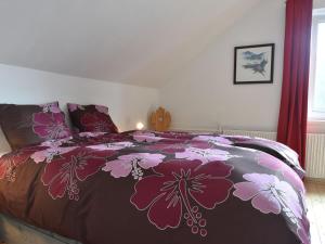 1 dormitorio con 1 cama grande con colcha de flores en Comfortable holiday home with private pool, en Levínská Olešnice