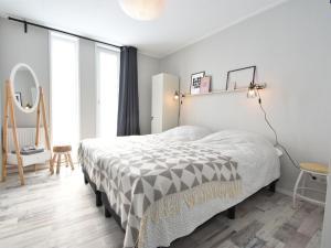 1 dormitorio con 1 cama con edredón blanco y negro en Classy Holiday Home in Sint Annaland Barbecue en Sint Annaland