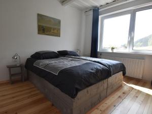 a large bed in a room with two windows at Comfortable holiday home with private pool in Levínská Olešnice