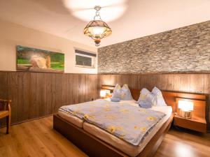 a bedroom with a large bed and a brick wall at Chalet in Gnesau in Carinthia with sauna in Gnesau