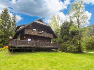 a large wooden house on a green field at Chalet in Gnesau in Carinthia with sauna in Gnesau