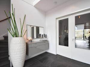 a bathroom with a vase with a sink and a mirror at Modern Villa in Harderwijk with Sauna and Jacuzzi in Harderwijk