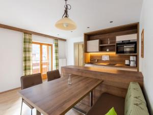 a kitchen and dining room with a wooden table at Apartment in Wald near Zillertal Ski Slopes in Wald im Pinzgau