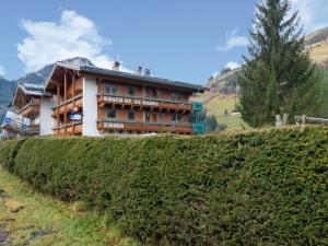 ヴァルト・イム・ピンツガウにあるQuaint Apartment in Wald im Pinzgau with Saunaの垣根の横の丘の上の建物