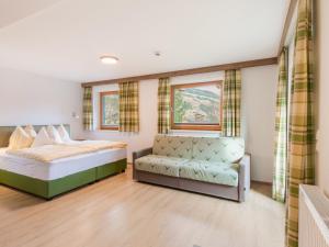 a bedroom with a bed and a couch at Apartment in Wald near Zillertal Ski Slopes in Wald im Pinzgau