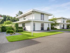 Biały dom z zielonym trawnikiem w obiekcie Modern Villa in Harderwijk with Sauna and Jacuzzi w mieście Harderwijk