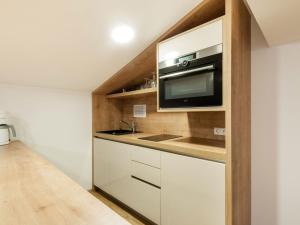 a kitchen with white cabinets and a microwave at Apartment in Wald near Zillertal Ski Area in Wald im Pinzgau
