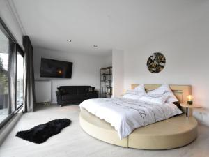 a bedroom with a large bed with a large window at Modern Villa in Harderwijk with Sauna and Jacuzzi in Harderwijk