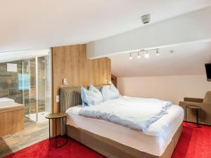 a bedroom with a large white bed and a bathroom at Apartment in Wald near Zillertal Ski Area in Wald im Pinzgau
