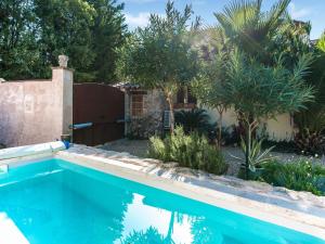 a swimming pool in a yard with a fence and trees at Charming holiday home in Lorgues with pool in Lorgues