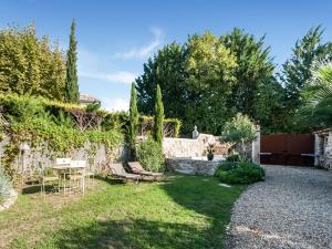 a garden with a table and chairs and a fence at Charming holiday home in Lorgues with pool in Lorgues