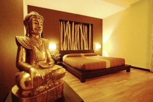 a bedroom with a bed and a statue of a man at Design Suite Tirano in Tirano