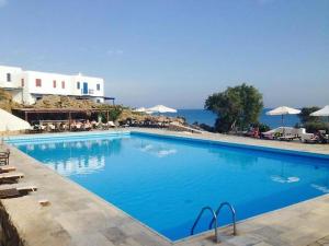 a large blue swimming pool next to the ocean at Opis studio in Ornos +22 photos
