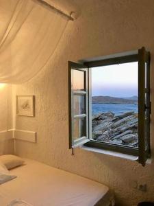 - une chambre avec une fenêtre donnant sur l'océan dans l'établissement Opis studio, à Ornos
