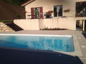 a swimming pool in front of a house at Le Mas de Servant Roulottes et chambres d'hôtes in Auberives-en-Royans