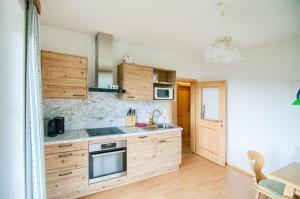 a kitchen with wooden cabinets and a stove top oven at Gästehaus Berger - Priglhof in Treffen