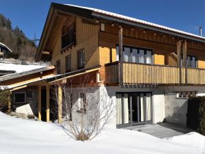 a wooden house with a balcony in the snow at Haus Berglust Wallgau in Wallgau