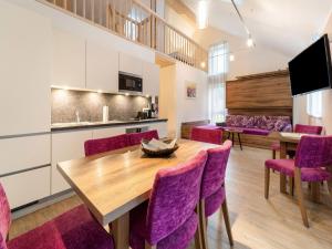 a dining room with a wooden table and purple chairs at Holiday home in St Georgen Salzburg near ski area in Fürstau