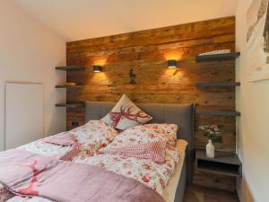 a bedroom with a bed with a wooden wall at Urbane Apartment in Kirchdorf in Tirol near Ski Area in Kirchdorf in Tirol