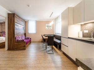 a kitchen and a living room with a table at Apartment in St Georgen Salzburg near ski area in Fürstau