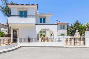 a large white house with a fence in front of it at Villa Constantina in Protaras