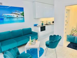 a living room with a blue couch and blue chairs at Aquarius Santorini in Boszkowo