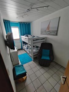 a small room with a bunk bed and a tv at Gästehaus 24 in Grettstadt