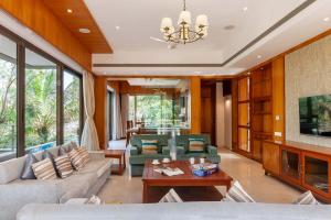 a living room with couches and a table at The Blue Horizon by StayVista - Featuring a beach-view villa with a swimming pool, indoor games, and a relaxing balcony in Alibaug