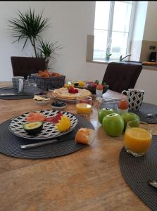 una mesa con platos de comida y fruta. en gite du château, en Saint-Samson