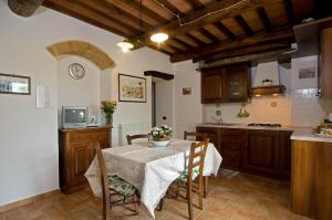a kitchen with a table and chairs in a kitchen at Agriturismo Fontesettimena APPARTAMENTO RONDINE- APPARTAMENTO CAPRIOLO in Volterra +17 photos