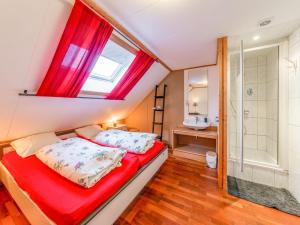 a bedroom with a red bed and a shower at Luxurious house with sauna in a farm in Bastogne in Bastogne