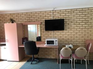 un ufficio con una scrivania con un computer su un muro di mattoni di Alamo Motor Inn a Nyngan