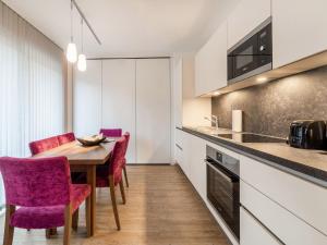 uma cozinha com uma mesa de madeira e cadeiras roxas em Apartment in St Georgen Salzburg near ski area em Fürstau