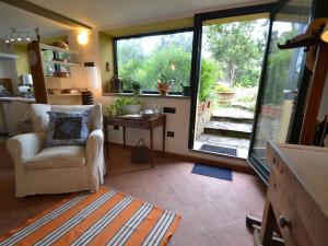 a living room with a chair and a large window at Belvilla by OYO La Selva in Impruneta