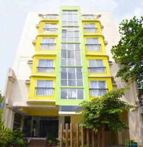 a yellow and white building with a fence at Sulit Budget Hotel VMapa in Manila