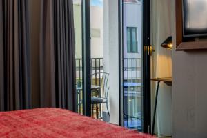 a room with a bed and a view of a balcony at Hotel Indigo Belgrade by IHG in Belgrade