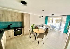 uma cozinha e sala de estar com uma mesa e um sofá em Marina Apartment by Dora em Keszthely