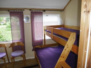 a bunk bed room with two bunk beds and two chairs at SovPå Tåg i Tärnsjö in Tärnsjö
