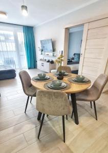 a dining room with a wooden table and chairs at Marina Apartment by Dora in Keszthely